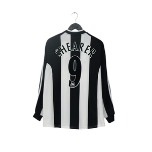 A black and white vertically striped long-sleeve soccer jersey hanging on a black hanger against a plain white background. The back of the jersey features the name 'SHEARER' and the number '9' in white.